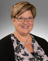 Headshot of Jennifer Thone wearing a black shirt with glasses and short hair